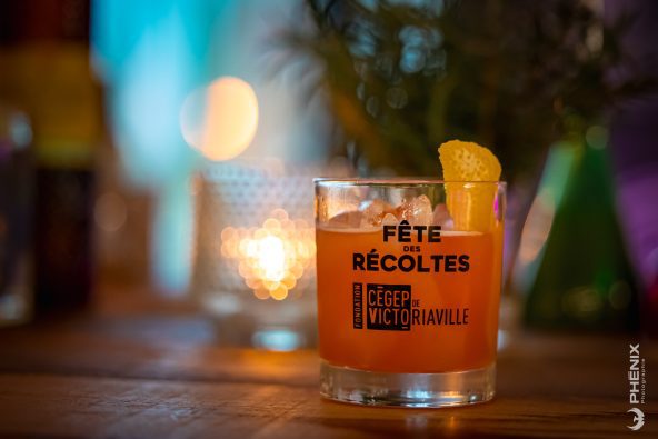 Photo de trois bouteilles de vin avec logo du Cégep de Victoriaville derrière