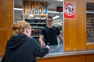 Photo du magasin où on voit un membre du personnel donnant un outil à un élève